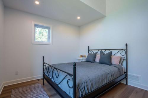 a bedroom with a black bed with a window at Spa Pool table Lake access - Le 515 Beaulac in Chertsey