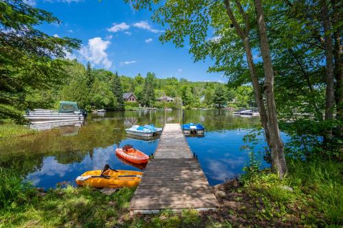 a dock with three boats on a lake at Spa Pool table Lake access - Le 515 Beaulac in Chertsey