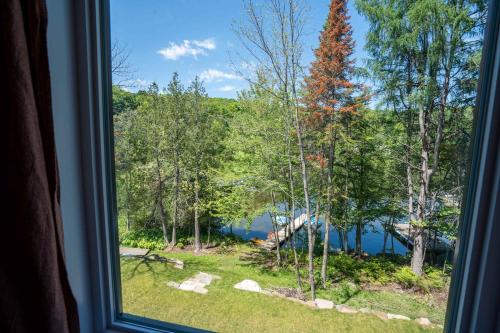 a view of a lake from a window at Spa Pool table Lake access - Le 515 Beaulac in Chertsey