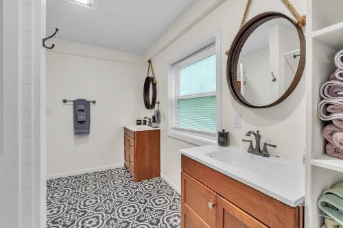 a bathroom with a sink and a mirror at The Glamorous Townhome by Granger Gardens in Ann Arbor