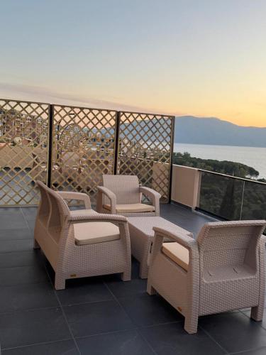 a group of chairs and tables on a balcony at Aloha Villa and Suites in Vlorë