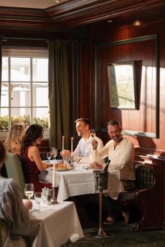a group of people sitting at a table in a restaurant at Hotel Maximilian in Bad Griesbach