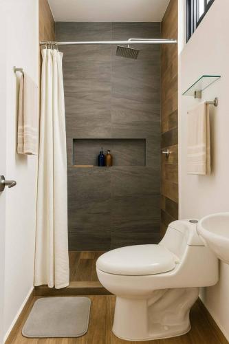 a bathroom with a toilet and a sink and a shower at Beautiful condo with 4 pools and roofgarden in Mazatlán