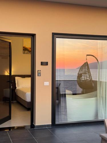 a room with a bed and a view of the ocean at Aloha Villa and Suites in Vlorë