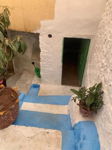 a house with blue and white floors and a door at كهوف يحيى لسياحة والمبيت البهاليل in Bhalil