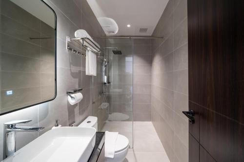 a bathroom with a sink and a toilet and a mirror at Sam Hotel & Apartment Da Nang in Da Nang