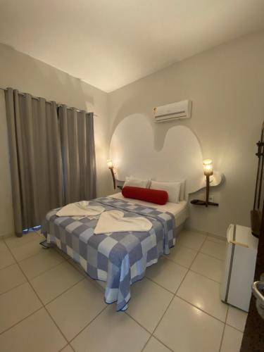 a bedroom with a bed with a blue and white blanket at Vila Verissimo in Jericoacoara