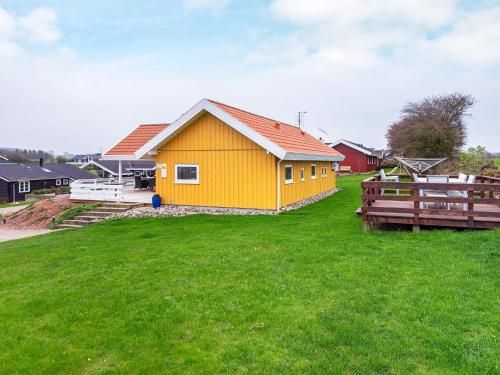 ein gelbes Haus in einem Feld aus grünem Gras in der Unterkunft 8 person holiday home in Nordborg-By Traum in Nordborg