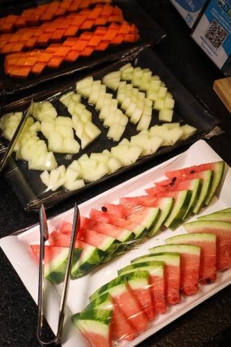 a buffet of food with fruits and vegetables on plates at Wanderlust Hostel in Maceió