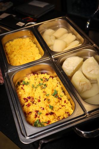 a tray with three trays of food and potatoes at Wanderlust Hostel in Maceió