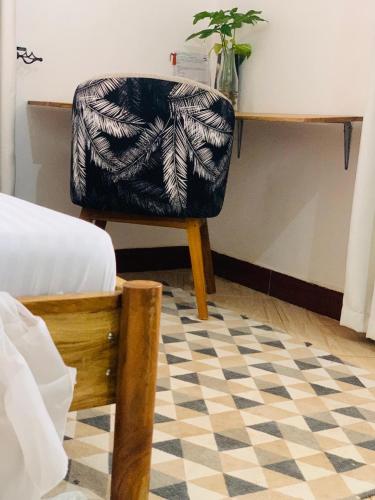 a chair sitting next to a desk in a room at Mkoani Homestay in Moshi
