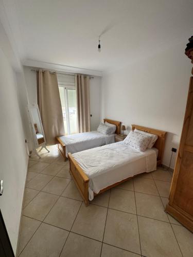 a bedroom with two beds and a window at Residence avec piscine in Martil