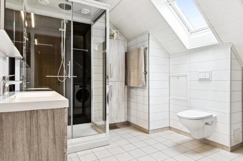 a bathroom with a toilet and a shower and a sink at Spacious 3-Bedroom Apartment with Balcony and Free Parking Orkland near Trondheim in Fannrem