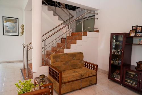 a living room with a couch and stairs at The Mist Residence - Kandy in Kandy