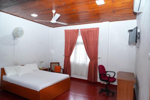 a bedroom with a bed and a chair and a ceiling fan at The Mist Residence - Kandy in Kandy