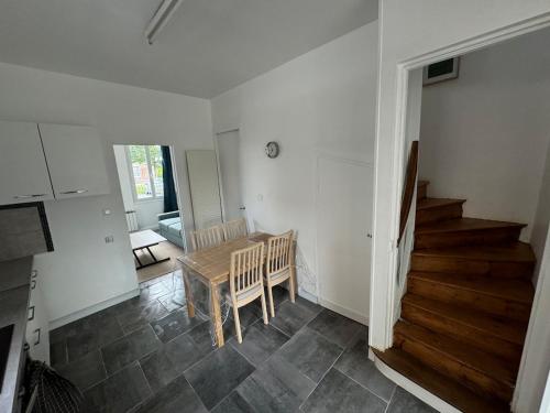 a kitchen and dining room with a table and stairs at Maison typique in Le Neubourg