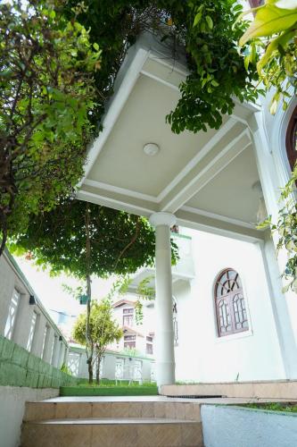 a white house with columns and trees at The Mist Residence - Kandy in Kandy