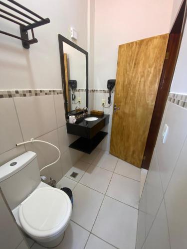 a bathroom with a toilet and a sink and a mirror at Vila Verissimo in Jericoacoara