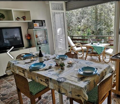ein Esszimmer mit Tisch und Stühlen und einem Fernseher in der Unterkunft Etrusca in Marina di Castagneto Carducci