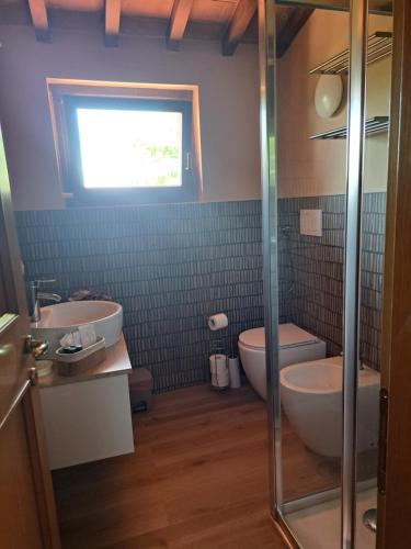 a bathroom with two sinks and a toilet and a window at Casa Madrigale in San Giovanni Valdarno