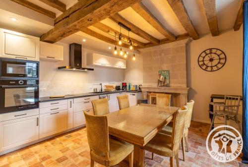 a kitchen with a wooden table and a dining room at Gîte Apolise in Saint-Rémy-la-Varenne