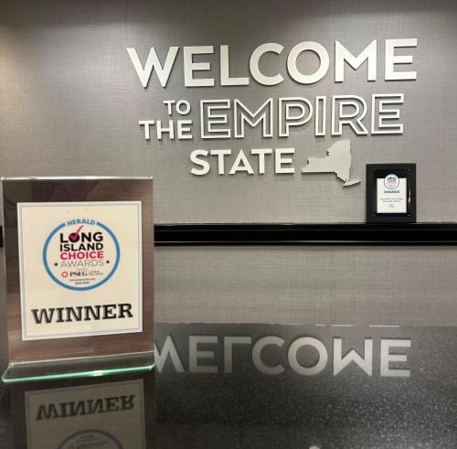 a welcome to the empire state sign on a wall at Hampton Inn & Suites By Hilton - Rockville Centre in Rockville Centre