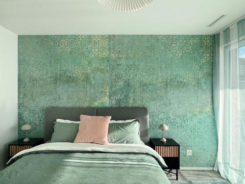 a bedroom with a bed with a green wall at Soleil House Saint Blaise in Saint-Blaise