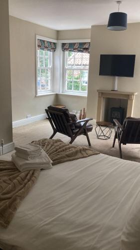 a bedroom with a bed and a chair and a fireplace at The Gillygate Inn in York
