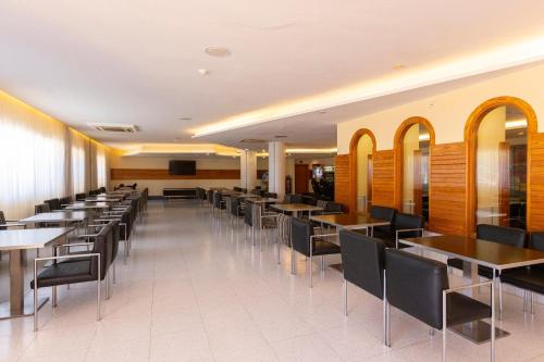 a row of tables and chairs in a restaurant at Invisa Ereso All Inclusive in Es Cana