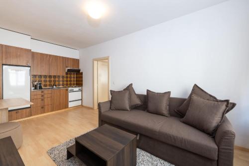a living room with a couch and a kitchen at Steps from Chantarella Lift - Skies Dream in St. Moritz