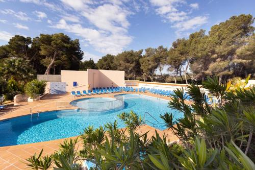 a swimming pool with blue chairs around it at Invisa Ereso All Inclusive in Es Cana