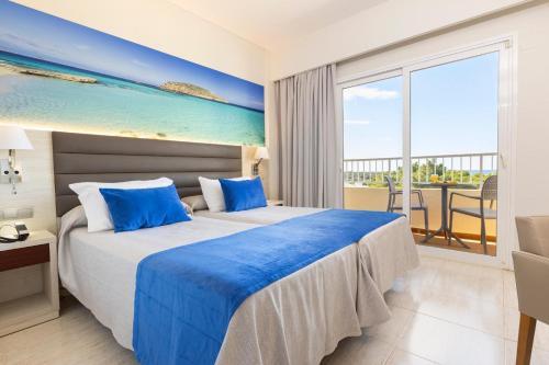 a bedroom with a bed and a view of the ocean at Invisa Ereso All Inclusive in Es Cana