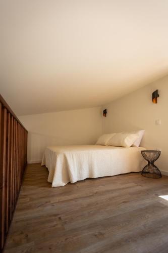 a bedroom with a bed and a wooden floor at Quinta Madureira in Alfolões