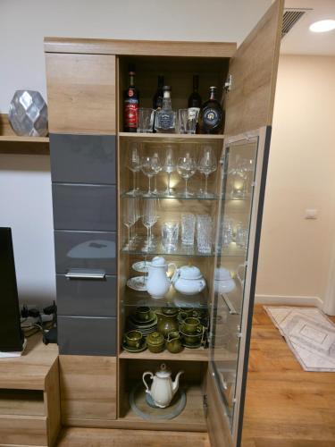 a cabinet filled with glasses and cups and bottles at Luxury Sea View Apartment in Vlorë