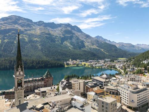 a view of a city with a lake and mountains at Ski Paradise Steps to Chantarella Lift in St. Moritz