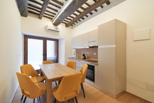 a kitchen and dining room with a wooden table and chairs at AM13 - Design retreat in Perugia