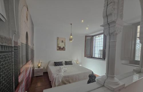 une chambre blanche avec un lit et une fenêtre dans l'établissement Le Grand Sultan 1492, Mirador San Nicolás, Parking included, à Grenade