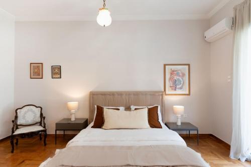 a bedroom with a bed and a chair and two lamps at Athenian Manor by Staycom in Athens