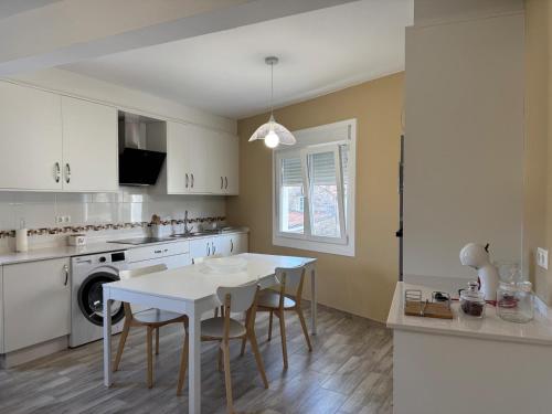 een keuken met een tafel en stoelen in een keuken bij Apartamento con huerta in San Mamede de Carnota