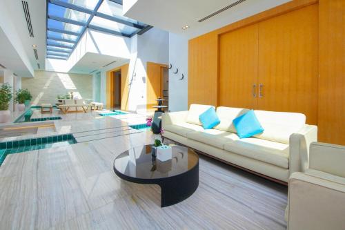 a living room with a white couch and a table at Royal Retreat Villa by Silk Valley at Nurai Island in Abu Dhabi