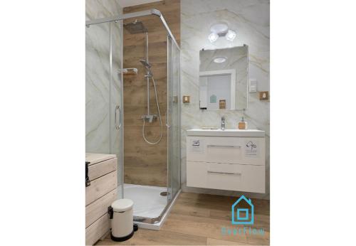 een badkamer met een douche en een wastafel bij Coast Apartment with Sauna & Gym, 5 Min to Baltic Sea & Polsat Plus Arena in Gdańsk