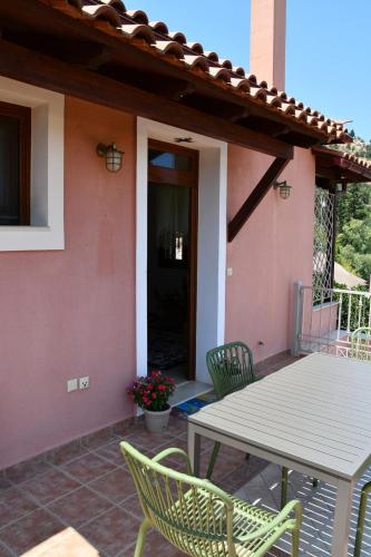 a patio with a table and chairs in front of a house at Blue and Green Guesthouse in Mystras