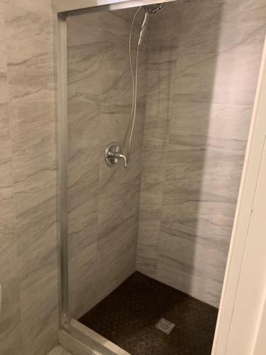 a shower with a glass door in a bathroom at Cozy multi-leveled apartment! in Rosebank