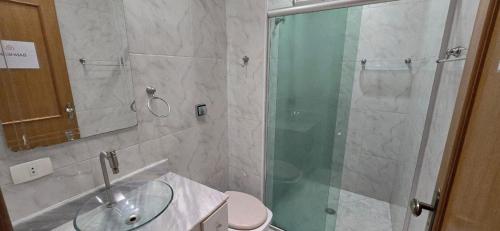 a bathroom with a glass shower and a toilet at Quarto Clara in Sao Paulo