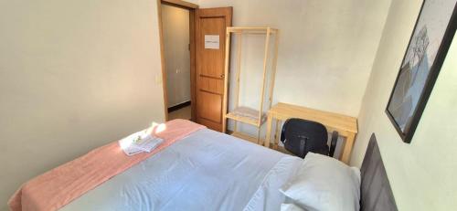 a small bedroom with a bed and a chair at Quarto Clara in Sao Paulo