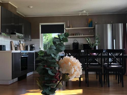 a kitchen with a table and a vase with a flower at Villa Tina in Hammarstrand