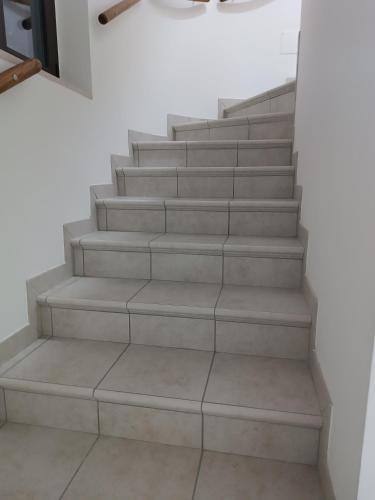 a set of stairs in a room with white walls at B&B "LE LUCI" CAMERA IN ATTICO SUPER VISTA interno 2 rose rosa in Vasto