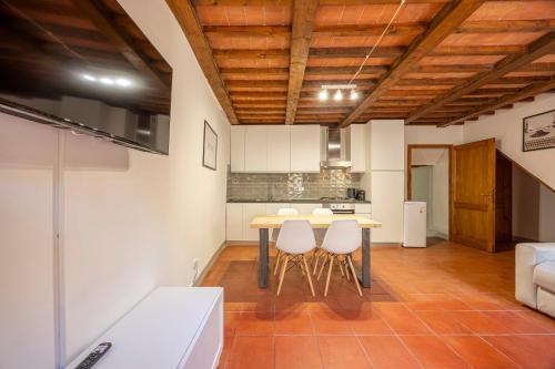 a kitchen with a table and chairs in a room at La Casetta di Ghiora in Falciano