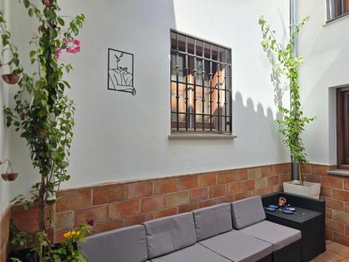 un mur de briques avec un canapé et une fenêtre dans l'établissement Le Grand Sultan 1492, Mirador San Nicolás, Parking included, à Grenade
