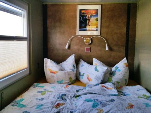 una camera da letto con letto, cuscini e lampada di Traumhaus-auf-dem-Wasser-Modernisiertes-Hausboot-13-x-4-m a Kützkow